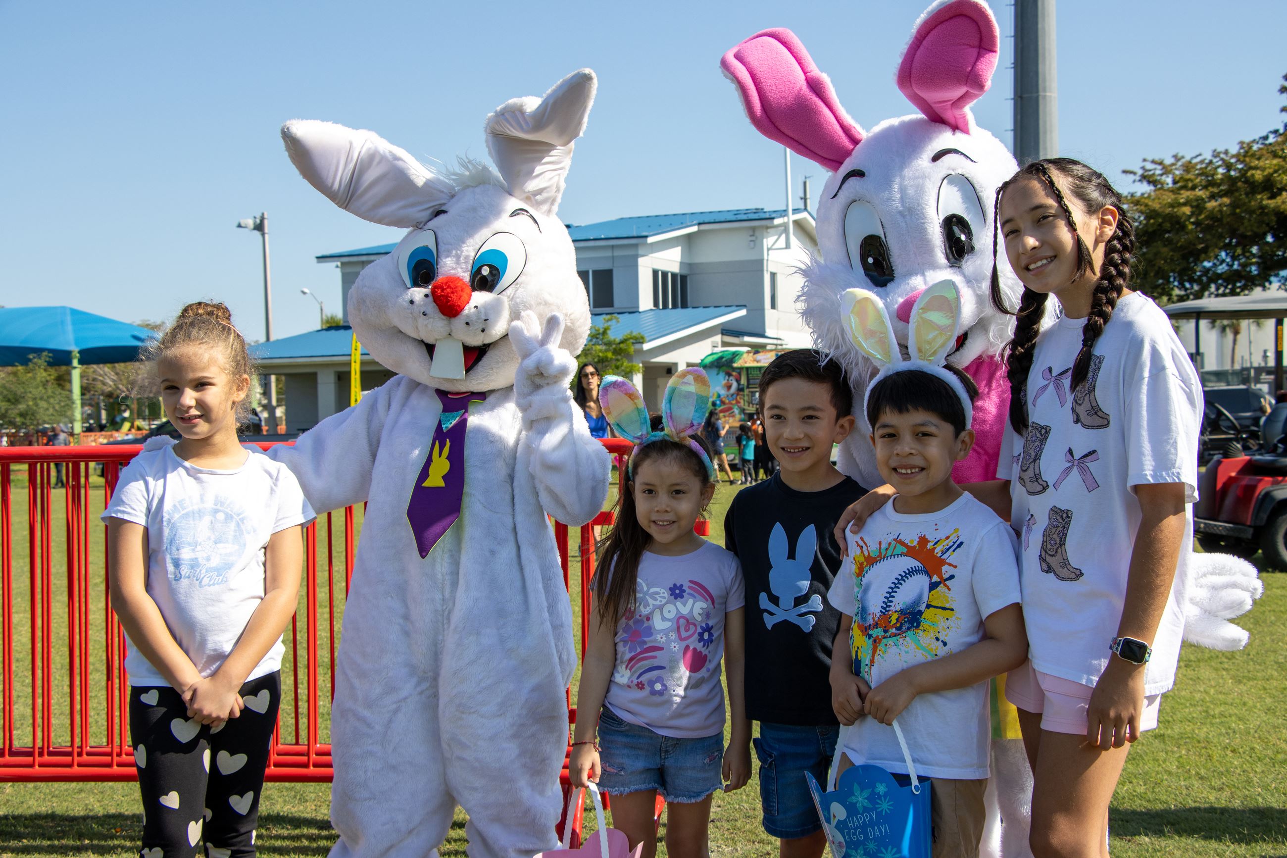 two people with bunny costumes and 5 kids smiling for a picture