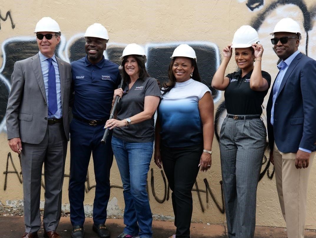 Persons smiling holding a brown plaque