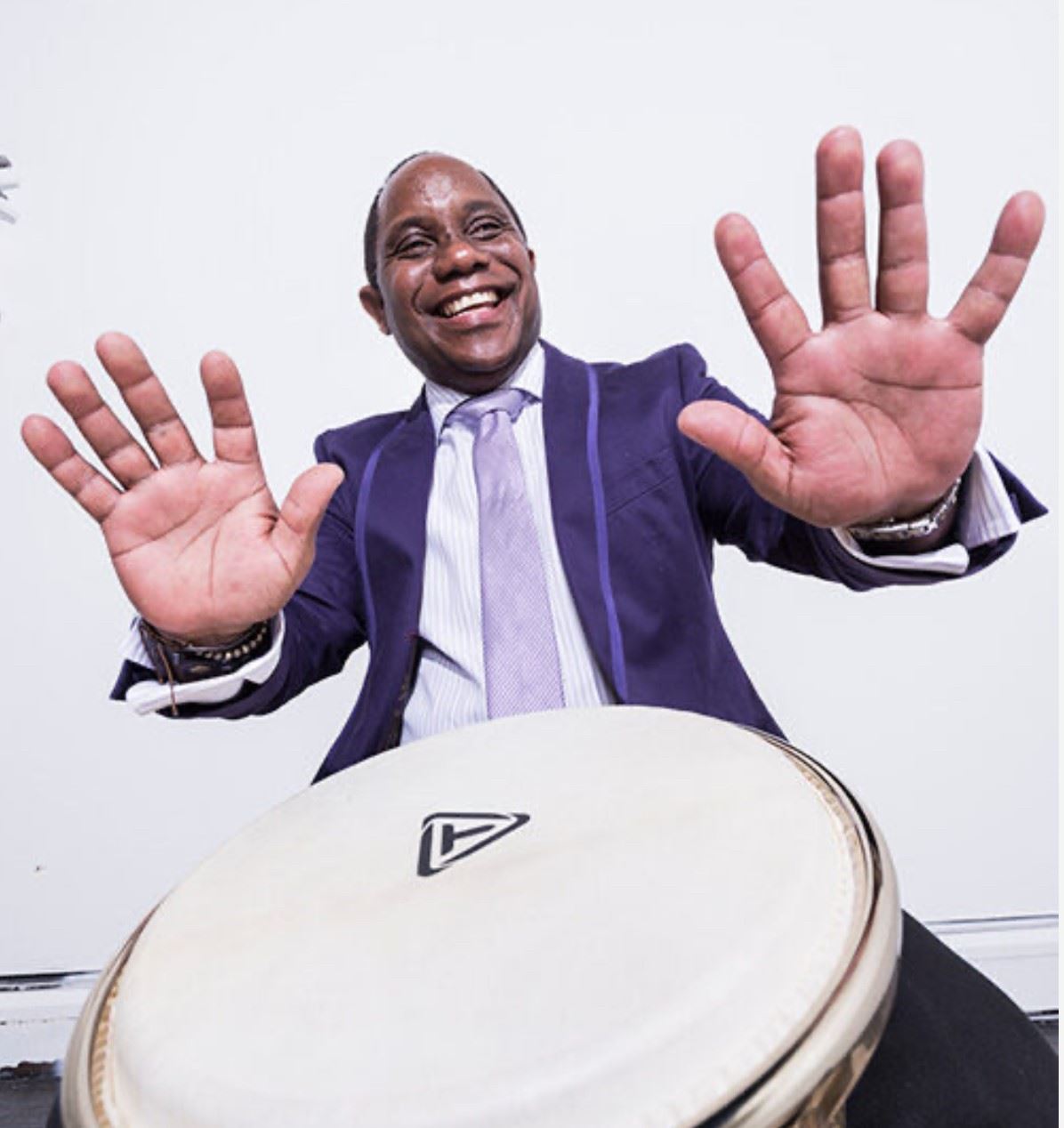 Man smiling sitting behind drums
